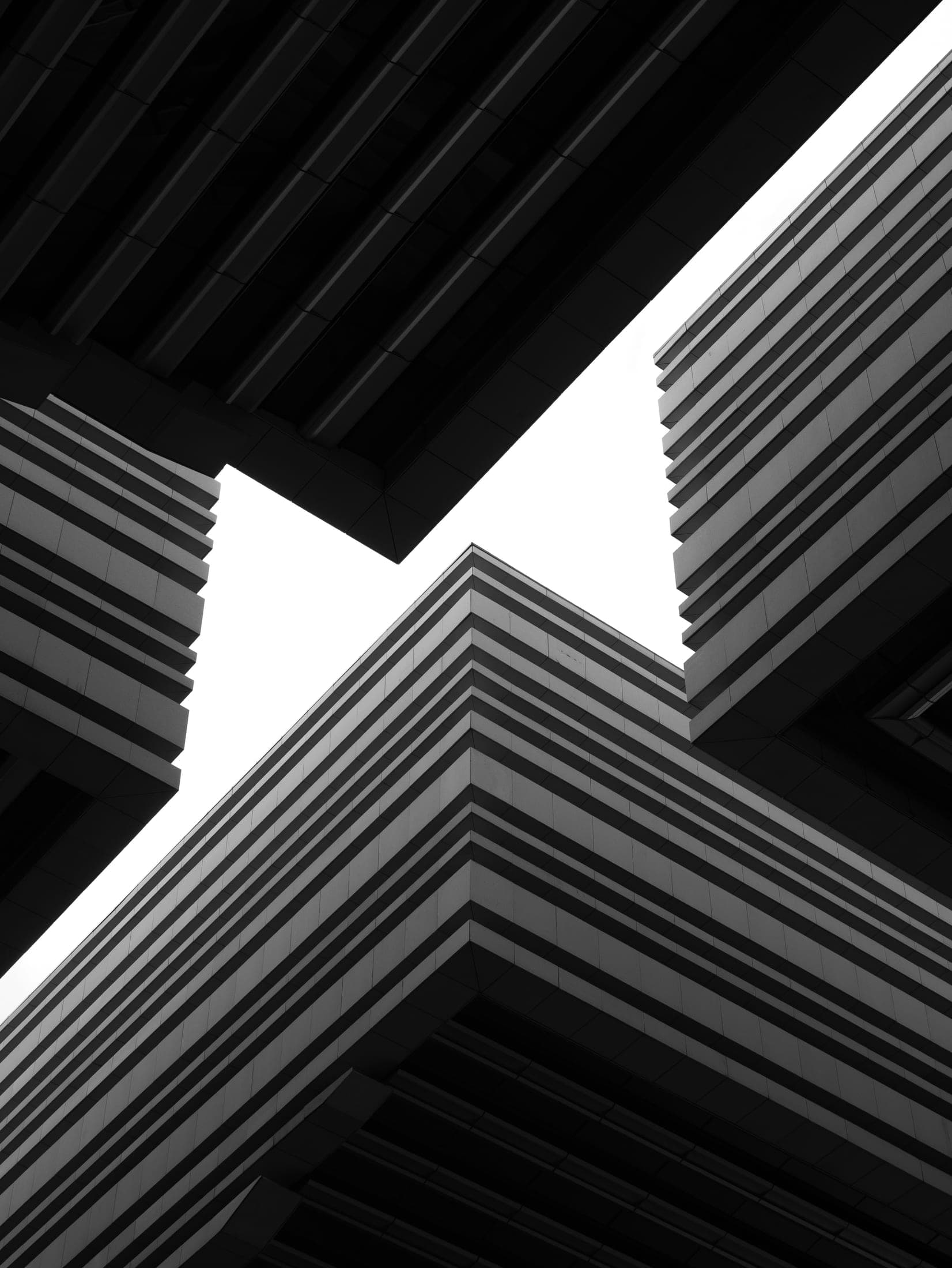 Angles de bâtiments striés, vus en contre-plongée.