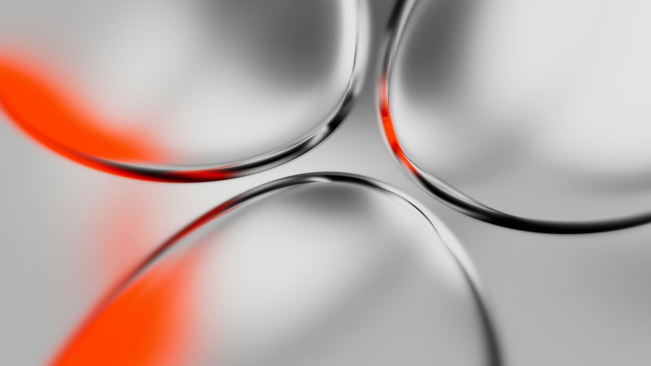 Formes de verre courbes traversées d’un éclat orangé.